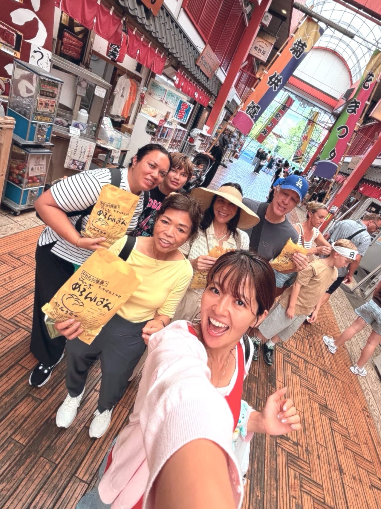 a guide's selfie with her guests in a covered market arcade